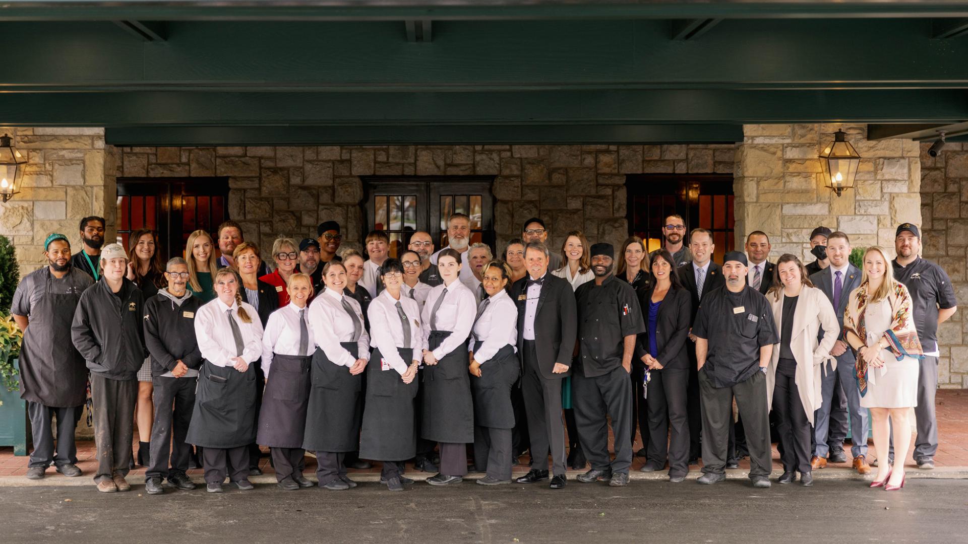 Keeneland team standing at the front of the clubhouse. Team wearing black and white clothes. 